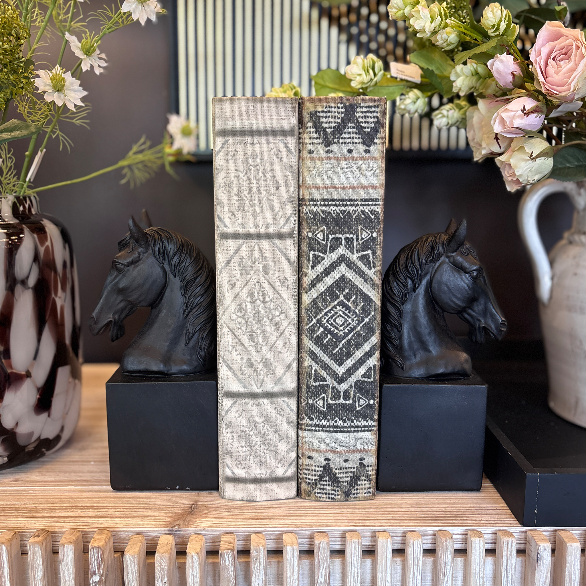 A sophisticated pair of horse head bookends finished in matte black, lending them a bold yet refined presence. Each bust sits atop a solid square stone plinth. 