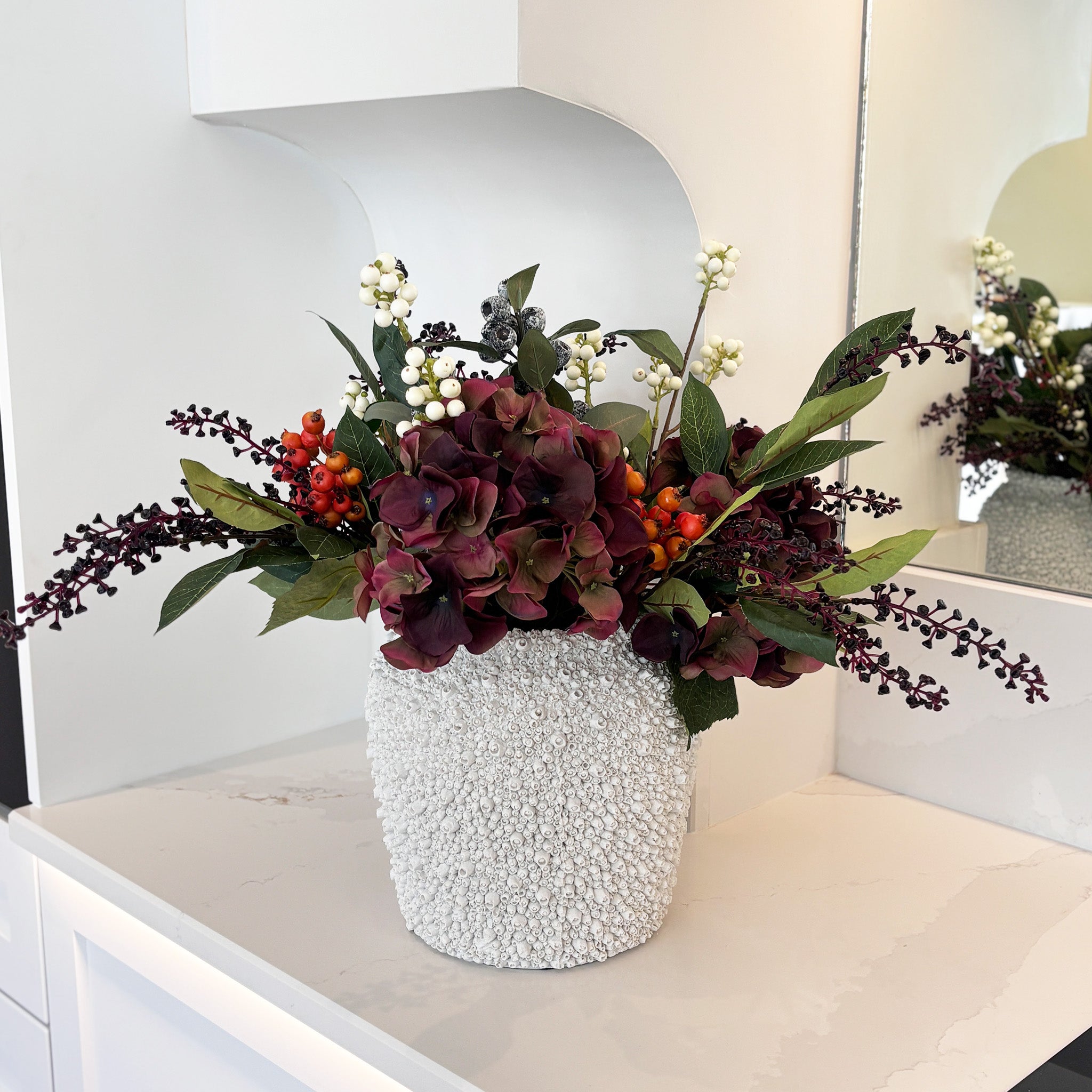 An arrangement of deep plum hydrangeas, clusters of glossy rosehips add warm bursts of orange, while creamy snow berries, for an autumnal look. Height: 53cm, Width: 60cm, Available with or without the vase, Delivery is approximately 2 to 10 working days, depending on stock availability                                                                                            