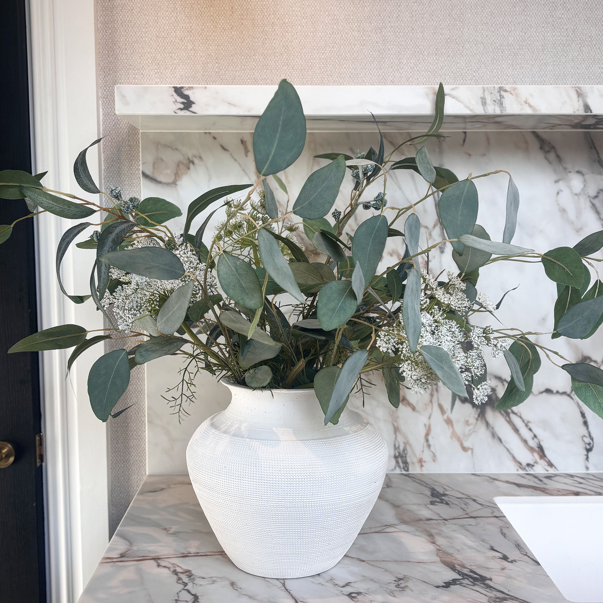 Wild Sage and Lace is a soft, airy display of wild-looking eucalyptus, gathered with berry eucalyptus sprays and delicate white meadow flowers in layered shades of sage, grey-green and cream, in our Olla textured vase. Overall Height: 60cm, Overall Width: 80cm, Delivery is approximately 2 to 10 working days, depending on stock availability