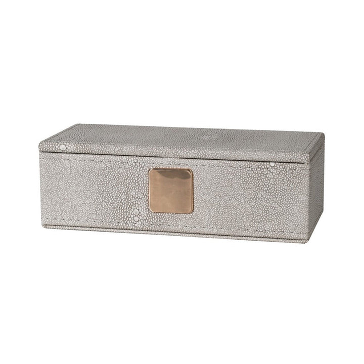 Faux shagreen lidded trinket box in ivory colour. The small circular texture of the shagreen skin is in a pale grey, giving it a two tone effect. The box has a matt gold sqaure badge on the front. 
Dimensions: H:60 W:180 D:80 mm