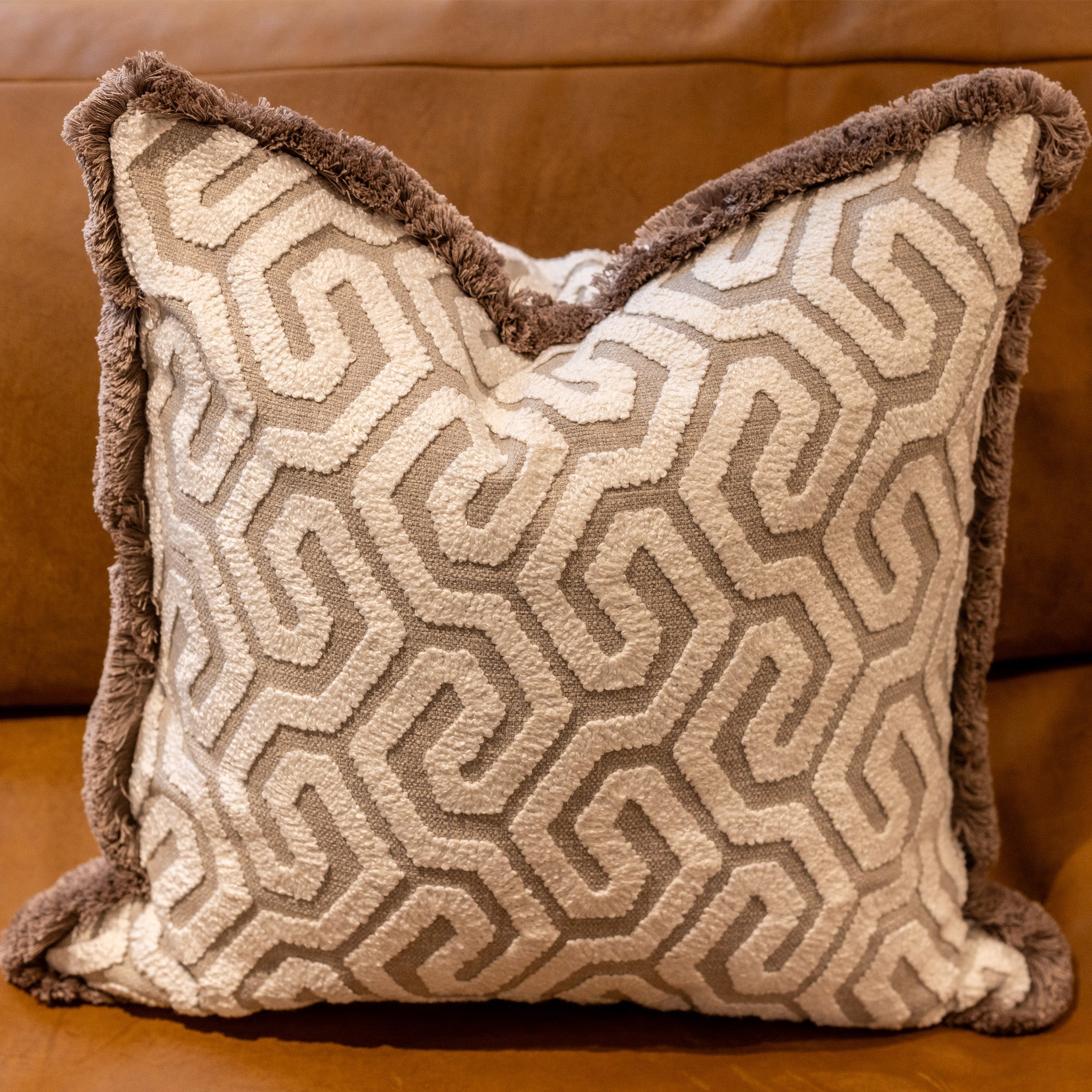 Three dimensional geometric pattern embroidered fabric in taupe and white with a mushroom coloured cotton brished fringe trim, with a plump feather inner cushion included.  Dimensions: 500 x 500 mm  Made to order in approx 3 weeks