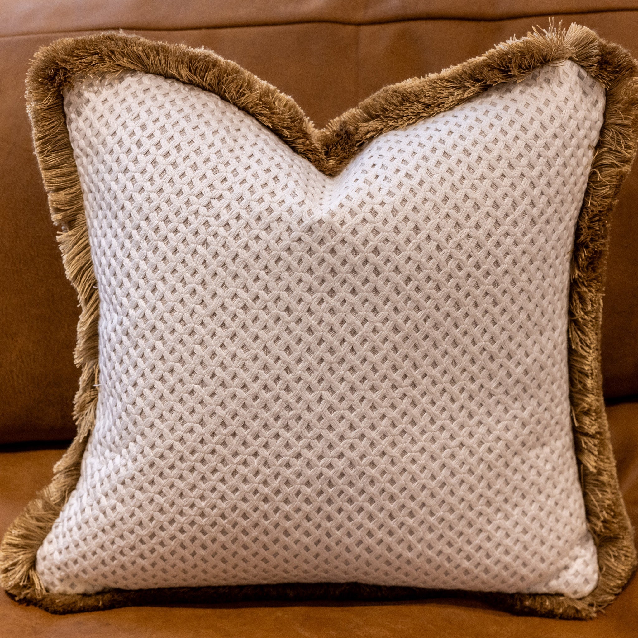 Two way cushion, geometric applique pattern fabric, white on an ecru background, with an ecru back, and gold fringing. A plump feather inner cushion included. Our made to order cushions are plump and cosy. Dimensions: 500 x 500 mm  Made to order in approx 3 weeks
