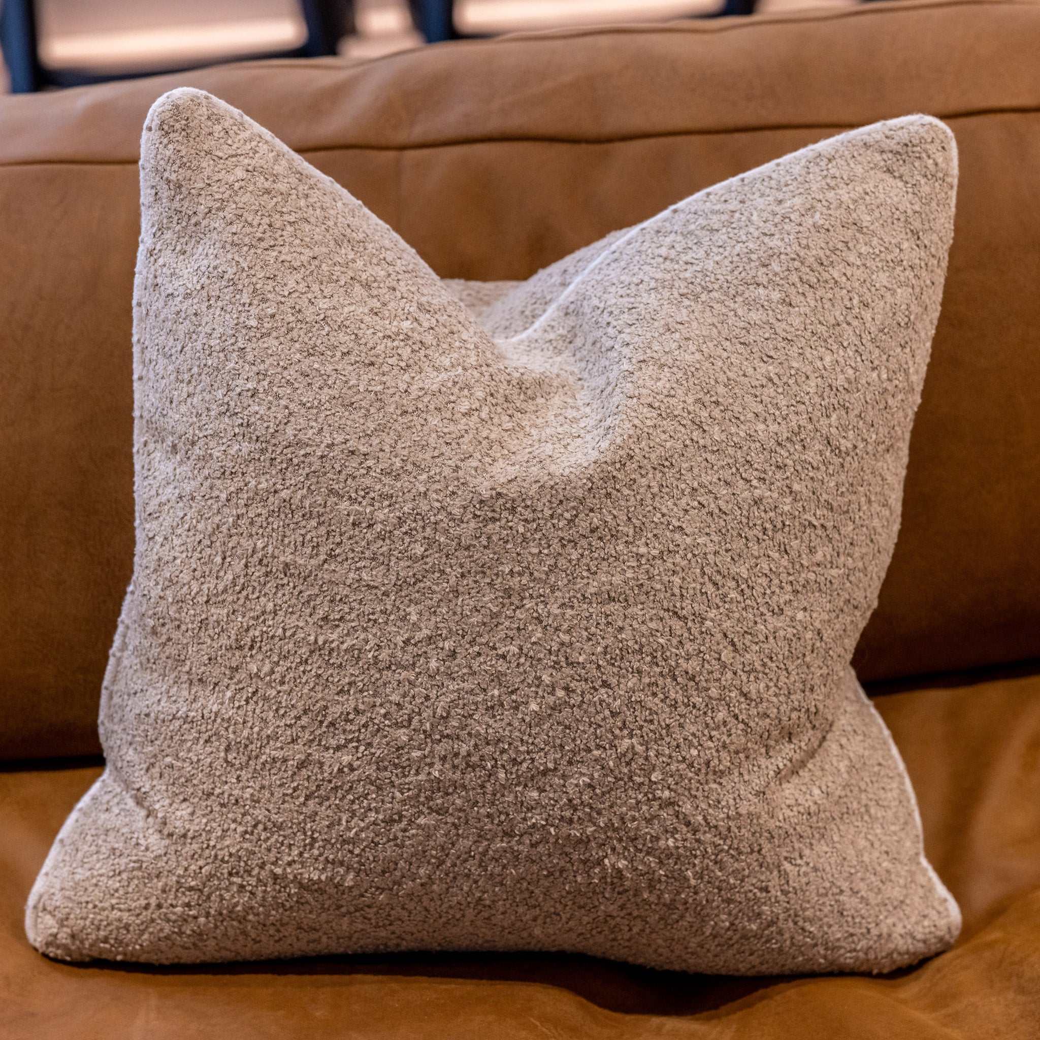 Luxury cushion in a taupe coloured boucle fabric, with a subtle linen mix striped fabric piping. A plump feather inner cushion is included. Our made to order cushions are plump and cosy.  Dimensions: 500 x 500 mm  Made to order in approx 3 weeks
